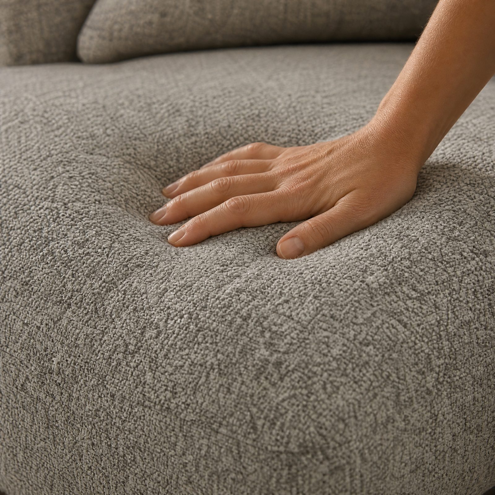 A hand resting on a soft, pebbled chenille cushion